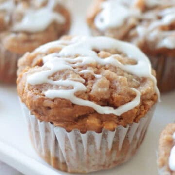 White platter with pumpkin muffins drizzled with vanilla glaze.