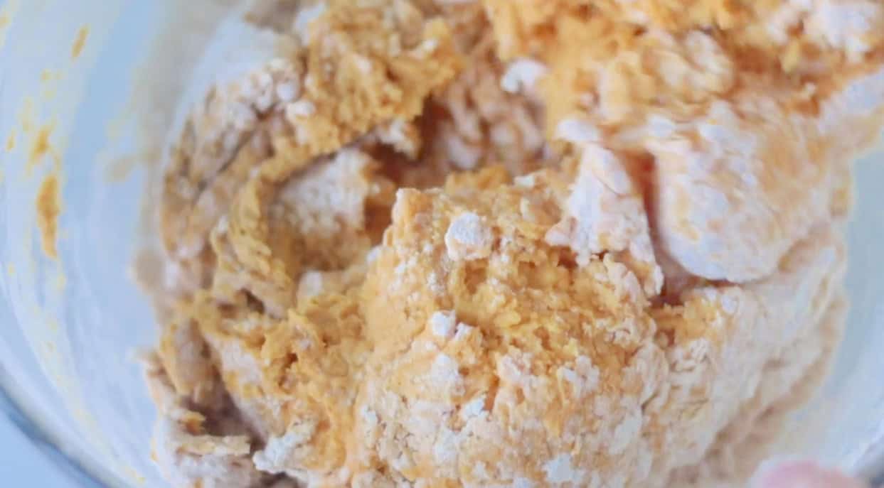 Pumpkin roll dough in a large mixing bowl.