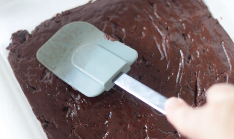 rubber spatula spreading fudge into pan