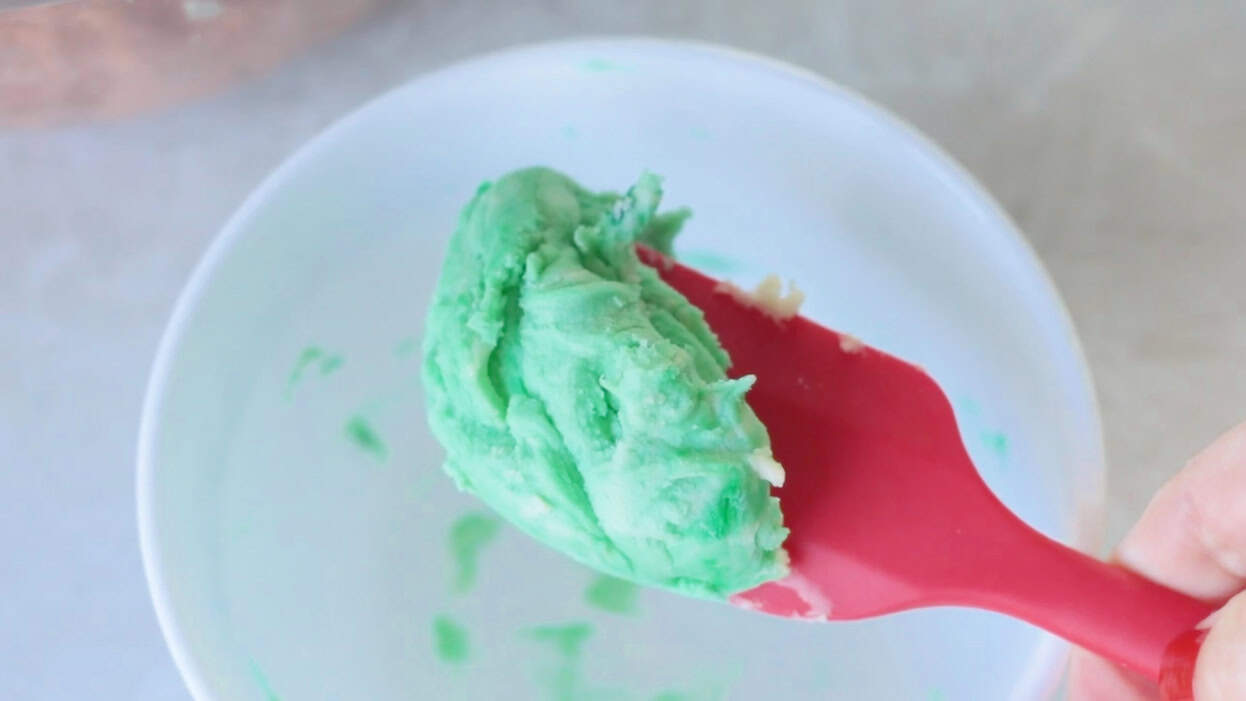 Green shortbread dough on rubber spatula.