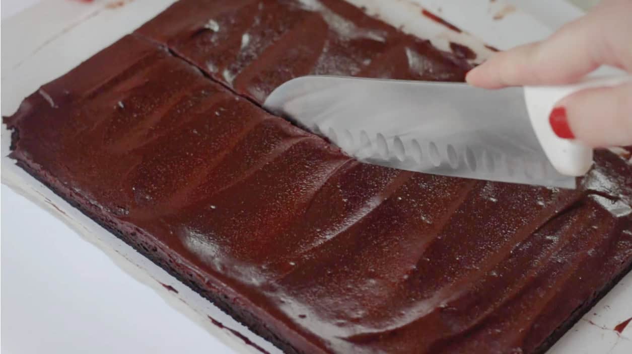 Sharp knife slicing brownies.
