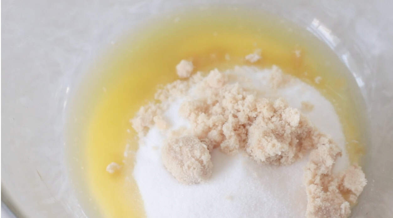 Mixing bowl of melted butter, sugar and brown sugar.