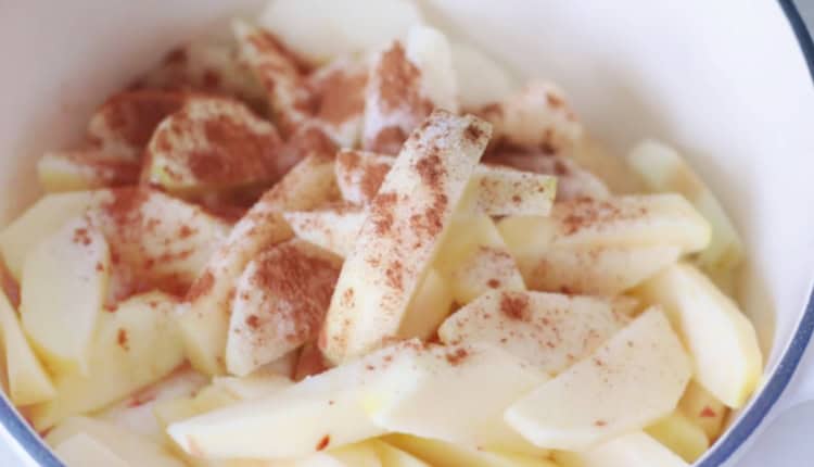 Sliced apples, cinnamon and sugar in pot.