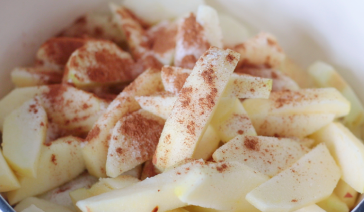 raw apples in pot with cinnamon and sugar