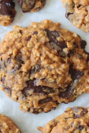 Pumpkin oatmeal chocolate chip cookies on parchment paper.