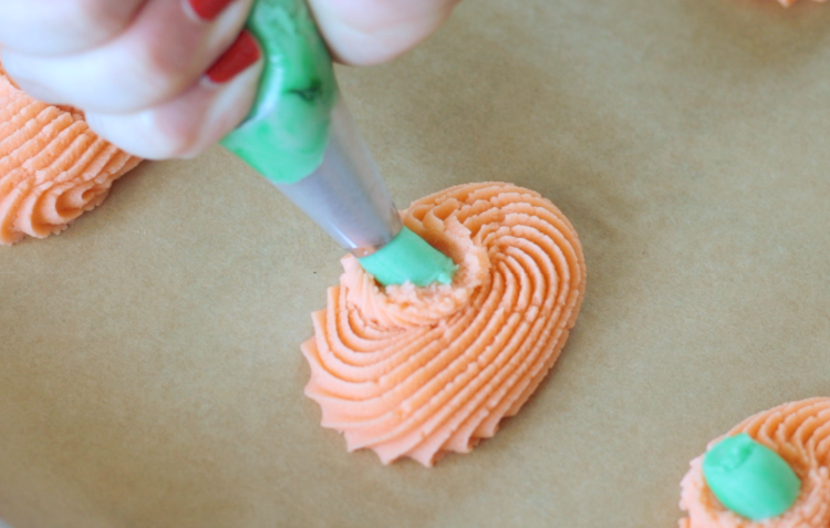 frosting bag piping green stem on cookies
