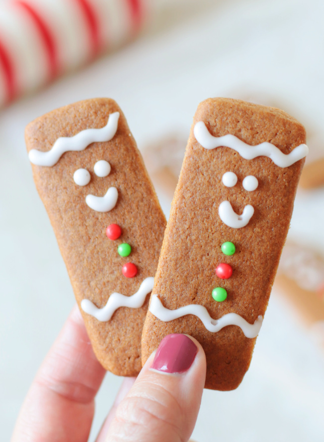 hand holding two gingerbread cookie sticks