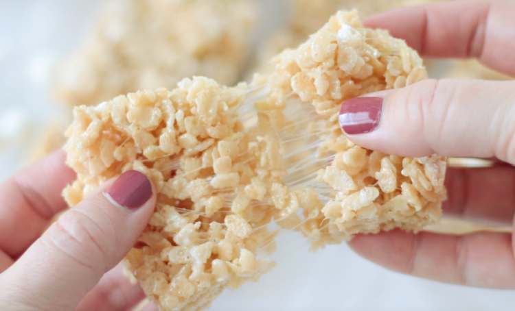 hand pulling Rice Krispies treat into two pieces