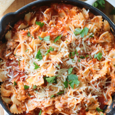 skillet of lasagna with cheese and chopped parsley
