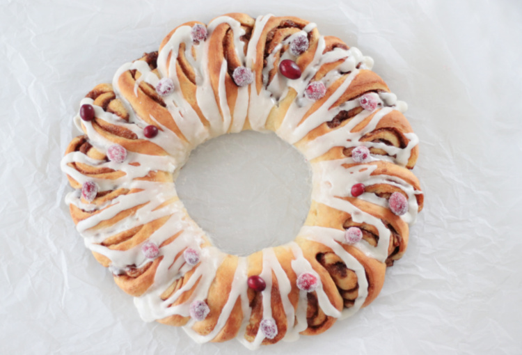 baked cinnamon roll wreath with cranberries and glaze