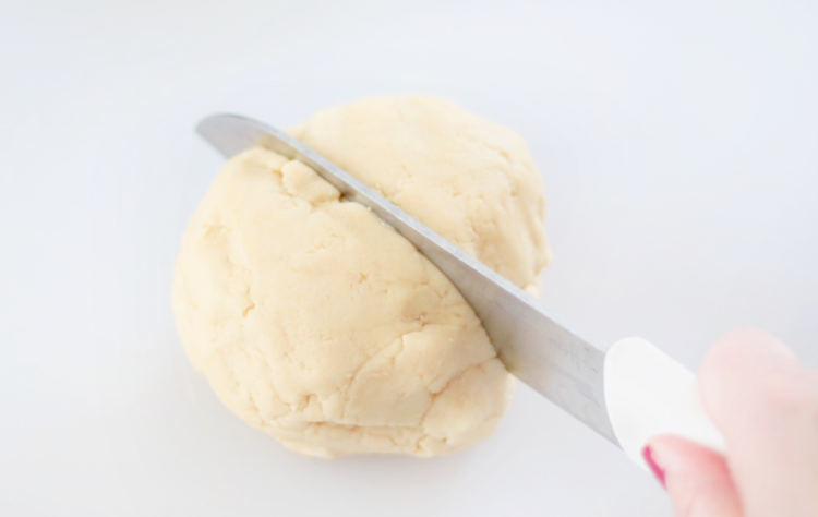 knife slicing cookie dough ball in half