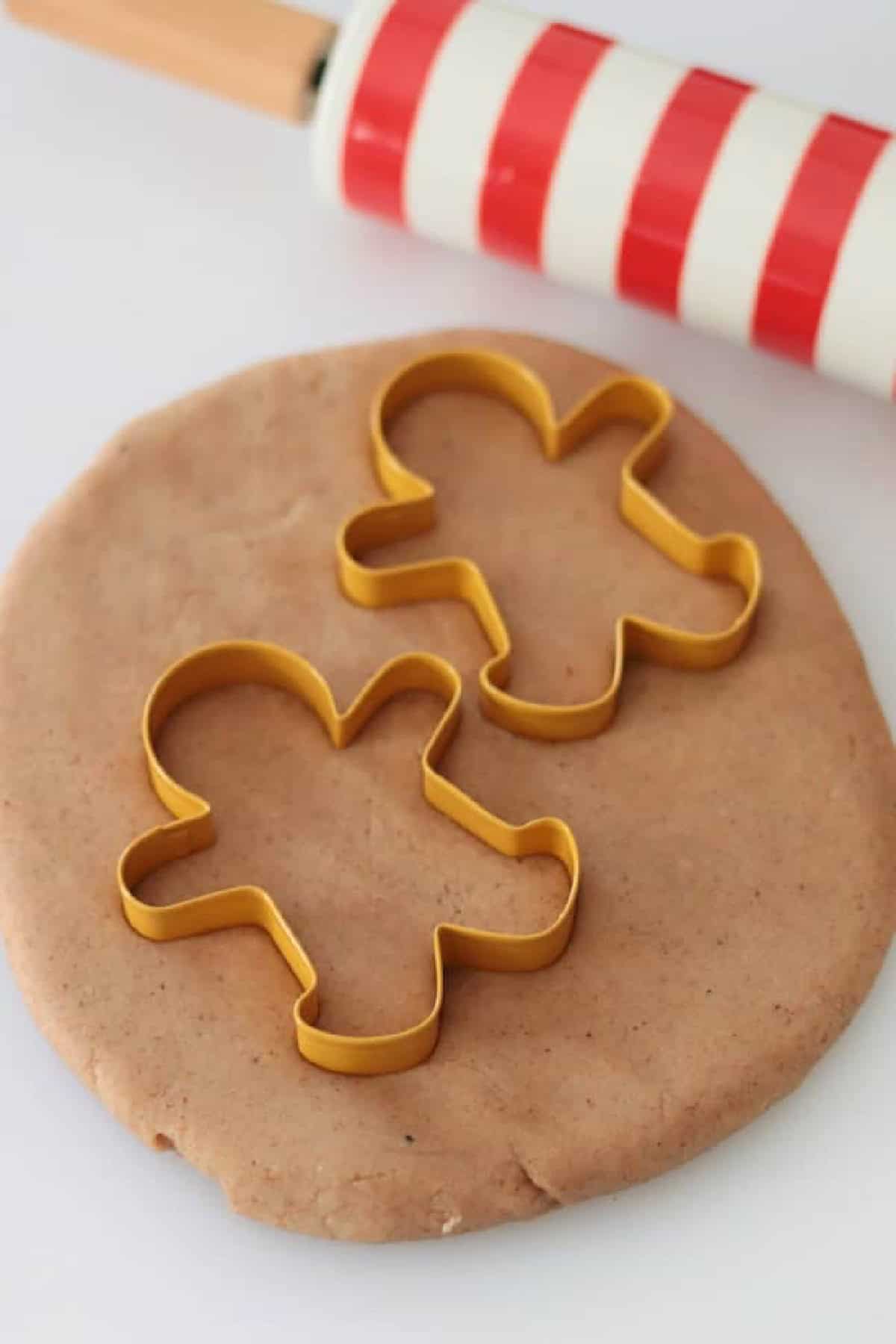 Gingerbread playdough with two gingerbread cookie cutters.