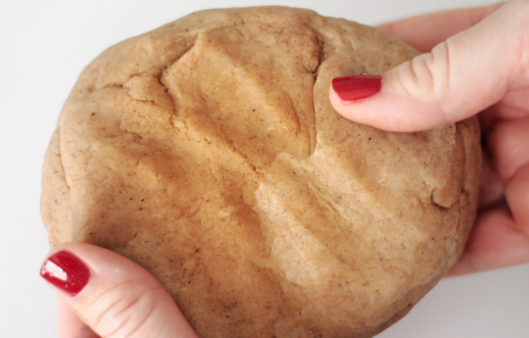 hands holding batch of gingerbread play dough