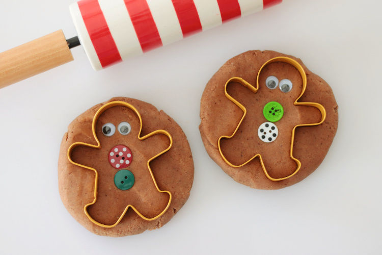 two balls of gingerbread play dough with gingerbread cookie cutters