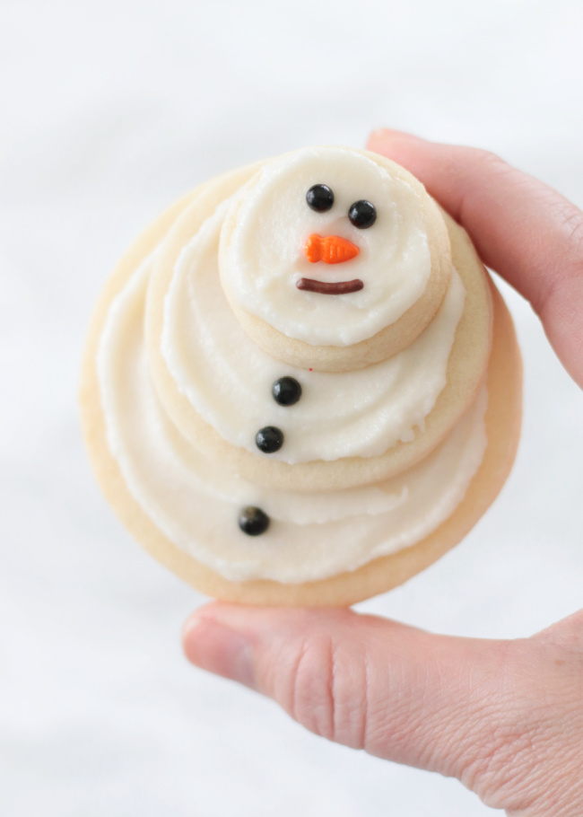 hand holding snowman sugar cookie