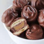 Bowl of Twix bites with one cut in half.