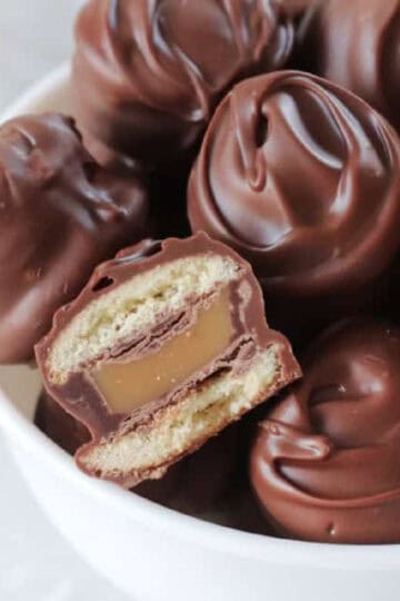 Bowl of Twix bites with one cut in half.