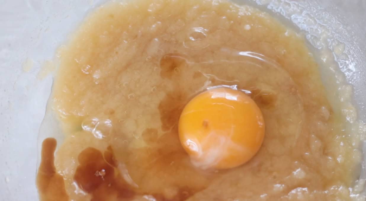 Bowl of melted butter, sugars, vanilla and an egg.