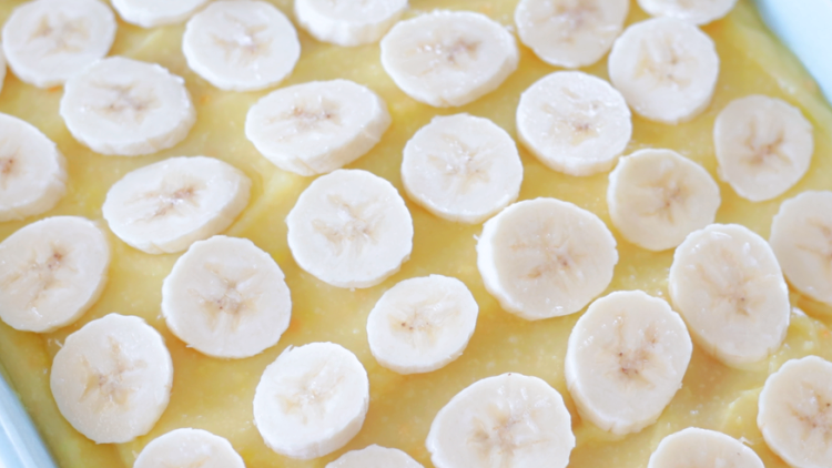 cake spread with banana pudding and sliced bananas.