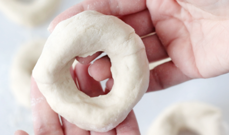 hand holding shaped bagel dough