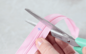 scissors trimming end of zipper