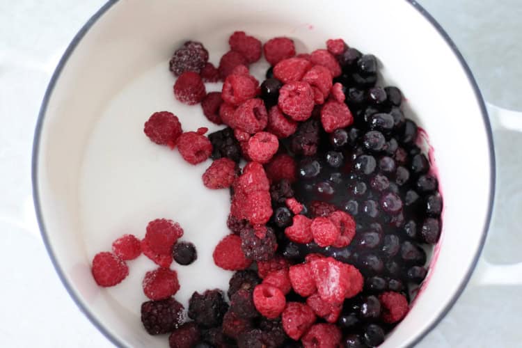 sugar, raspberries, blueberries and blackberries in pot