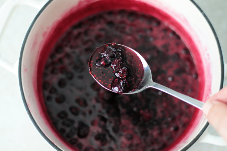 bot of simmered berry jam and spoon