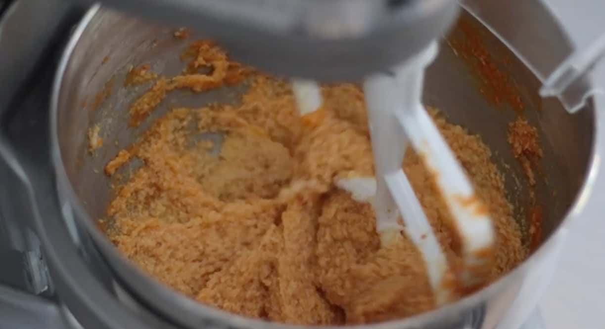 Creamed butter, sugar, and pumpkin puree in mixing bowl.