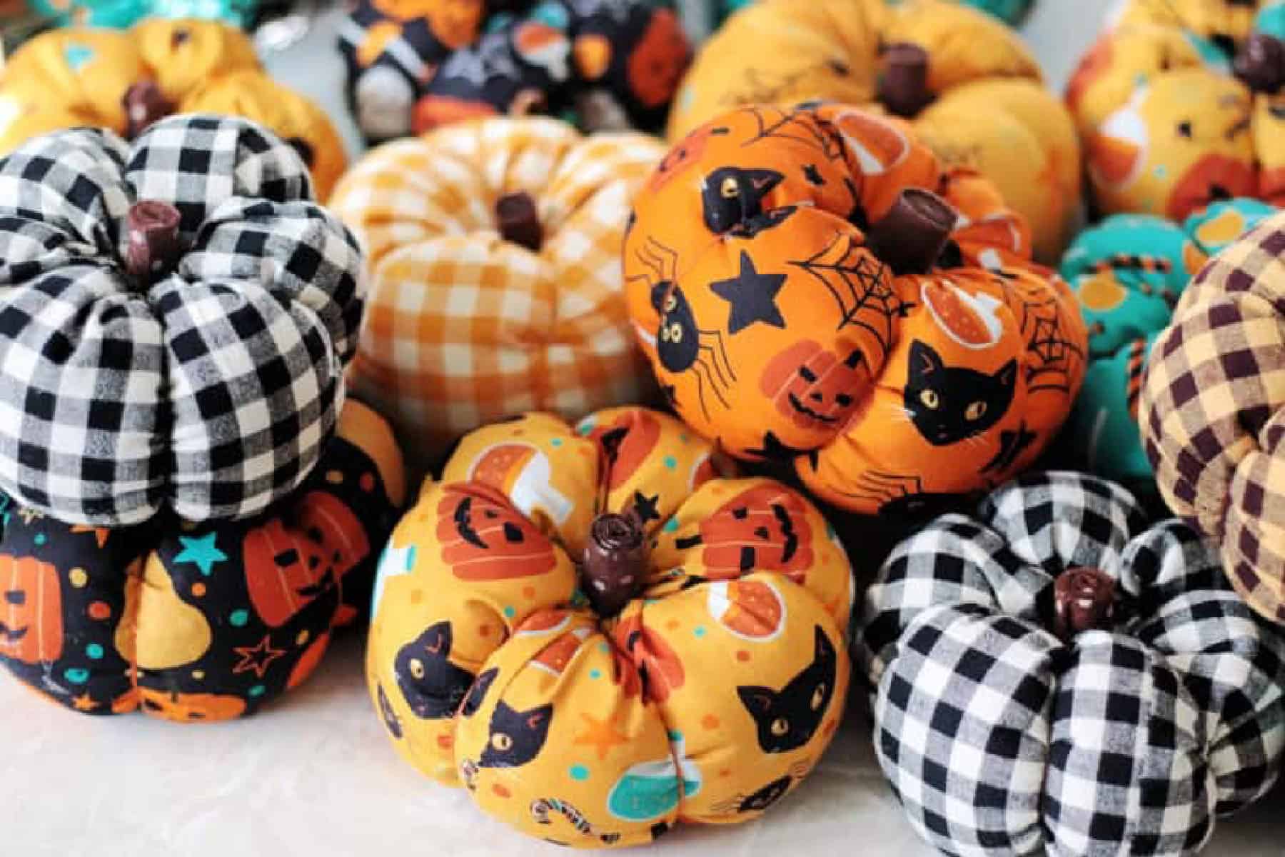 Pile of fabric pumpkins in various fabrics.