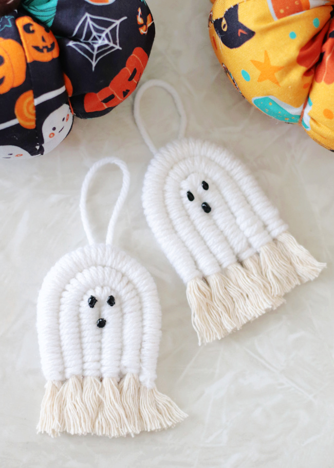two macrame ghosts on a table