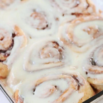 Baking pan of cinnamon rolls with icing.