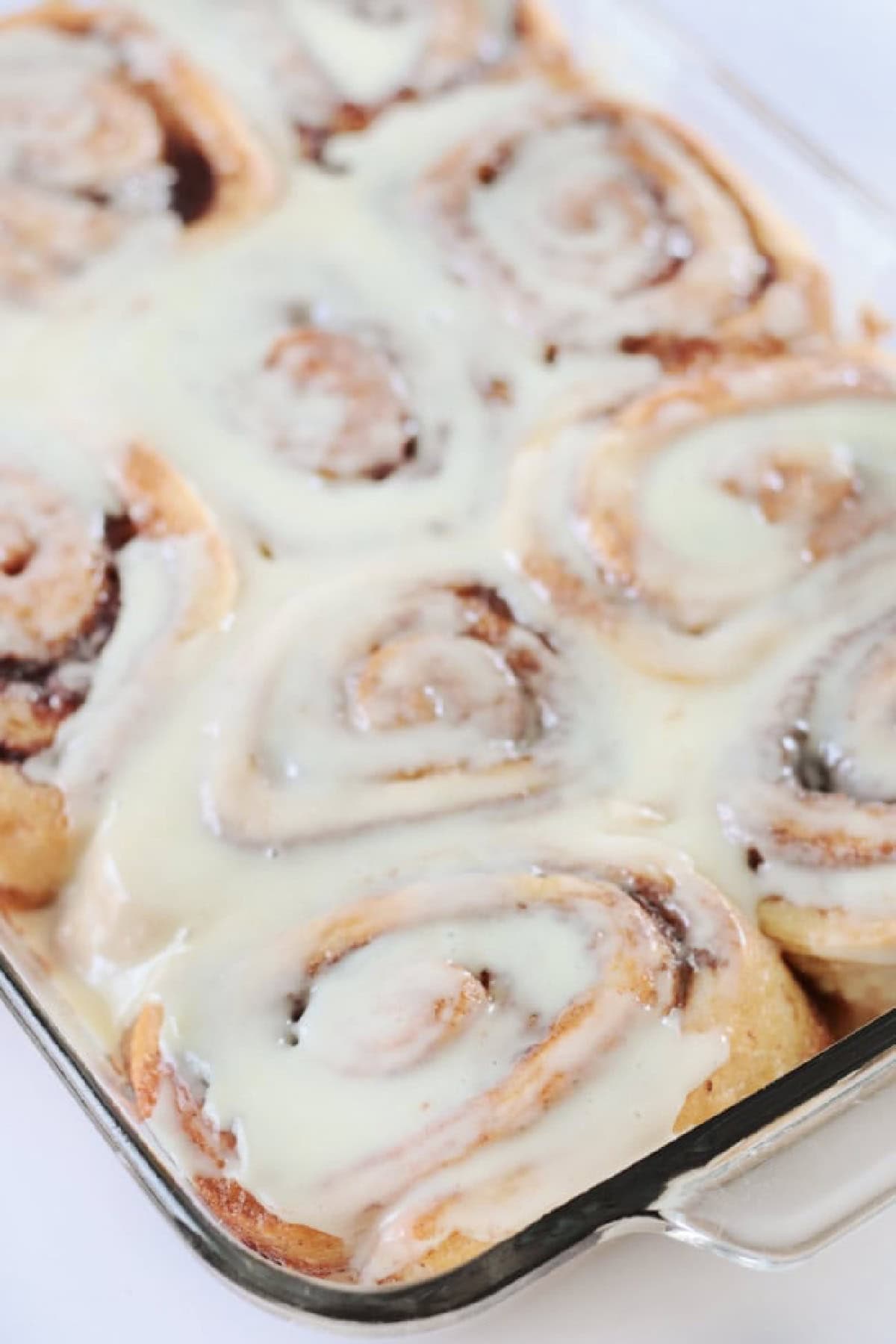 Baking pan of cinnamon rolls with icing.