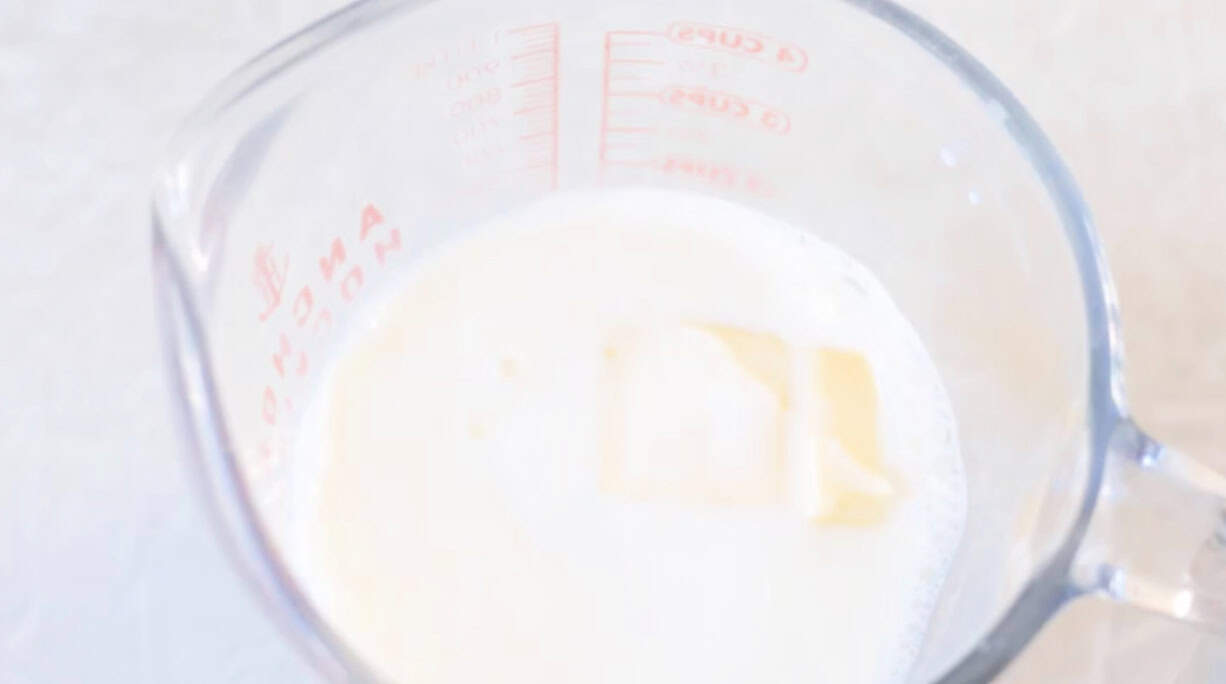 Glass measuring bowl with milk and butter.