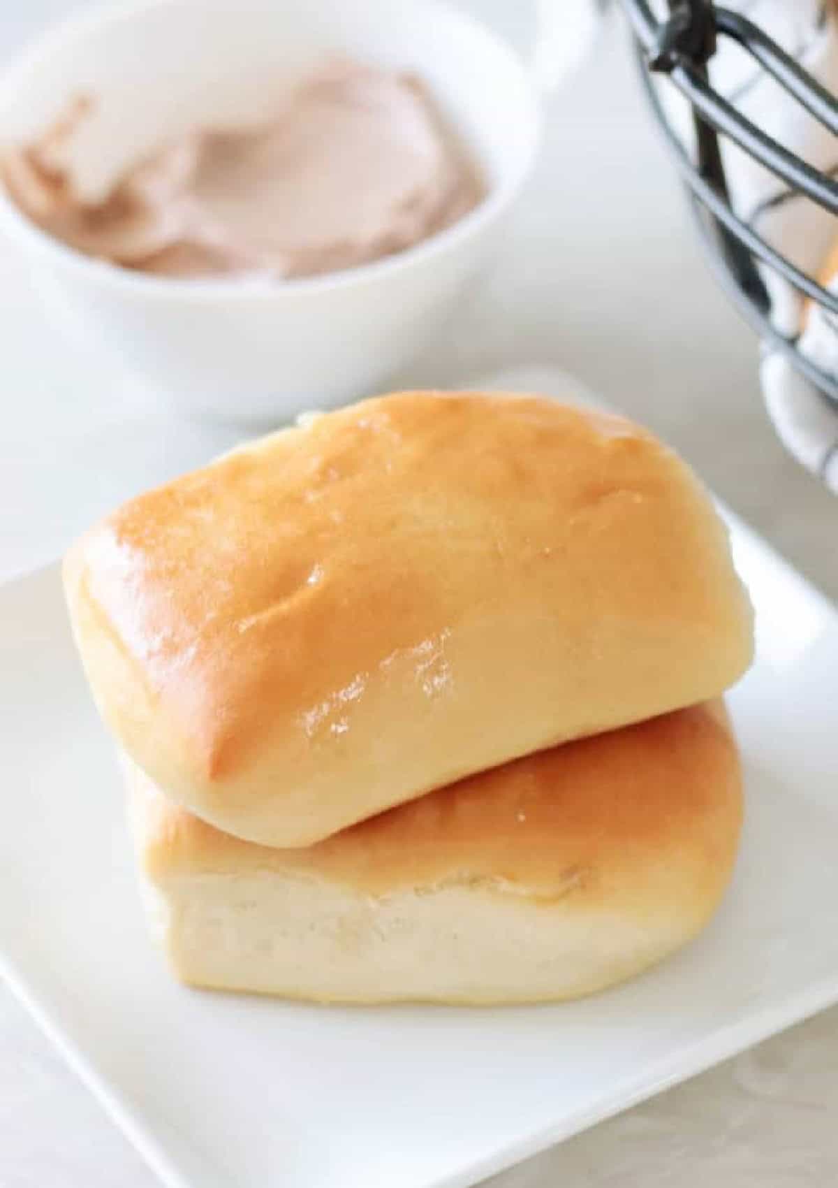 Two rolls stacked on a white plate.