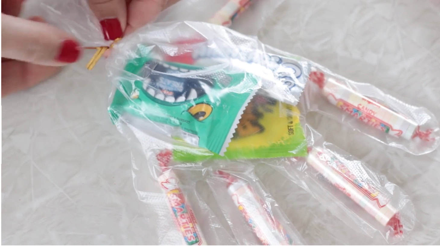 Hand twisting a twist tie on candy glove.