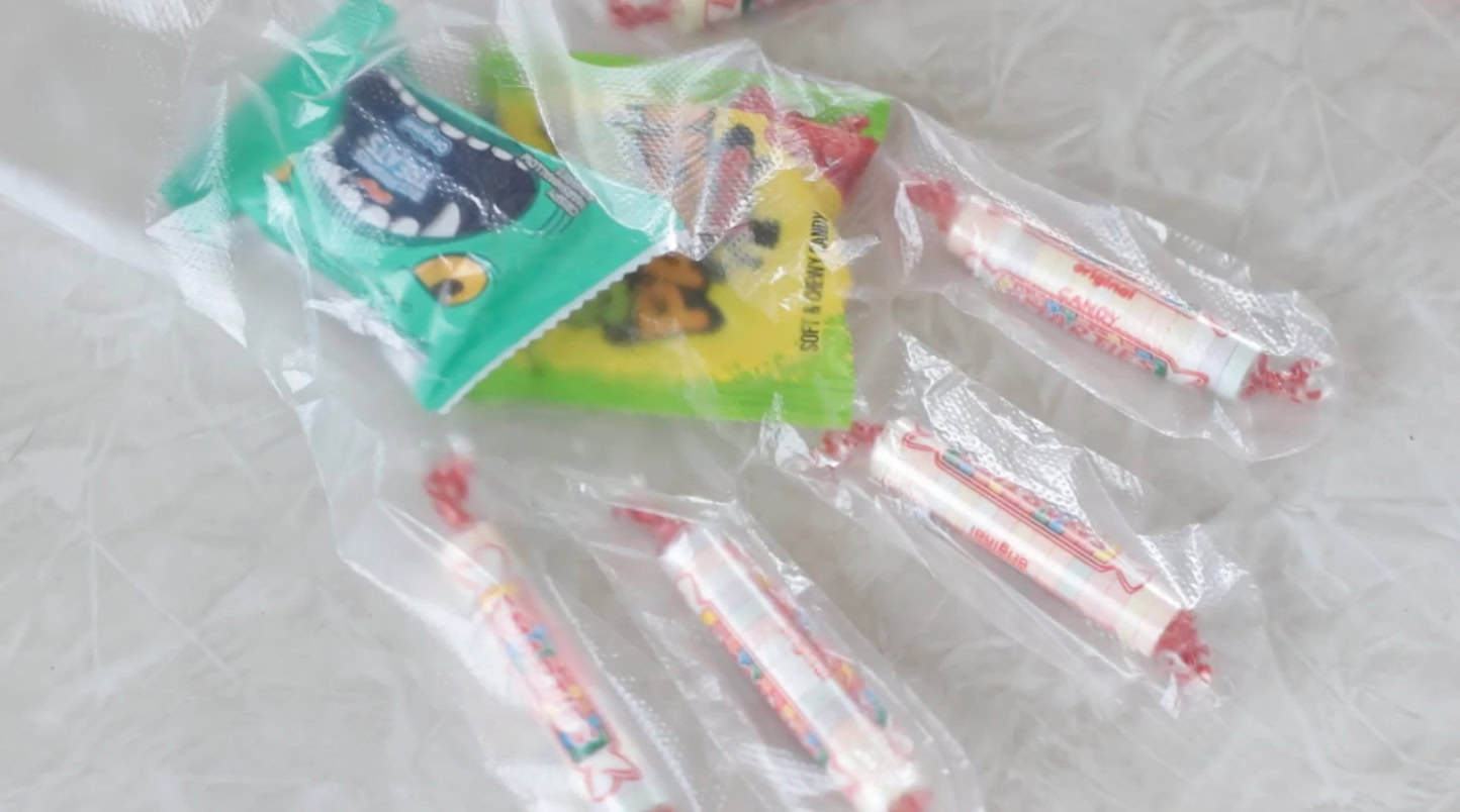 Hand placing candy inside candy glove.