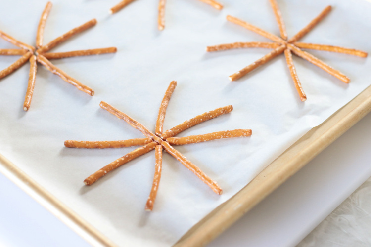 pretzel sticks on parchment paper baking sheet