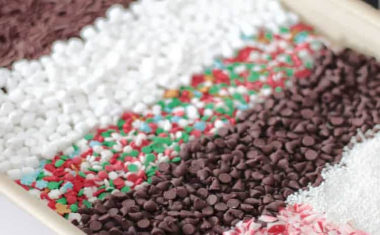 Baking sheet with rows or candy and sprinkles.