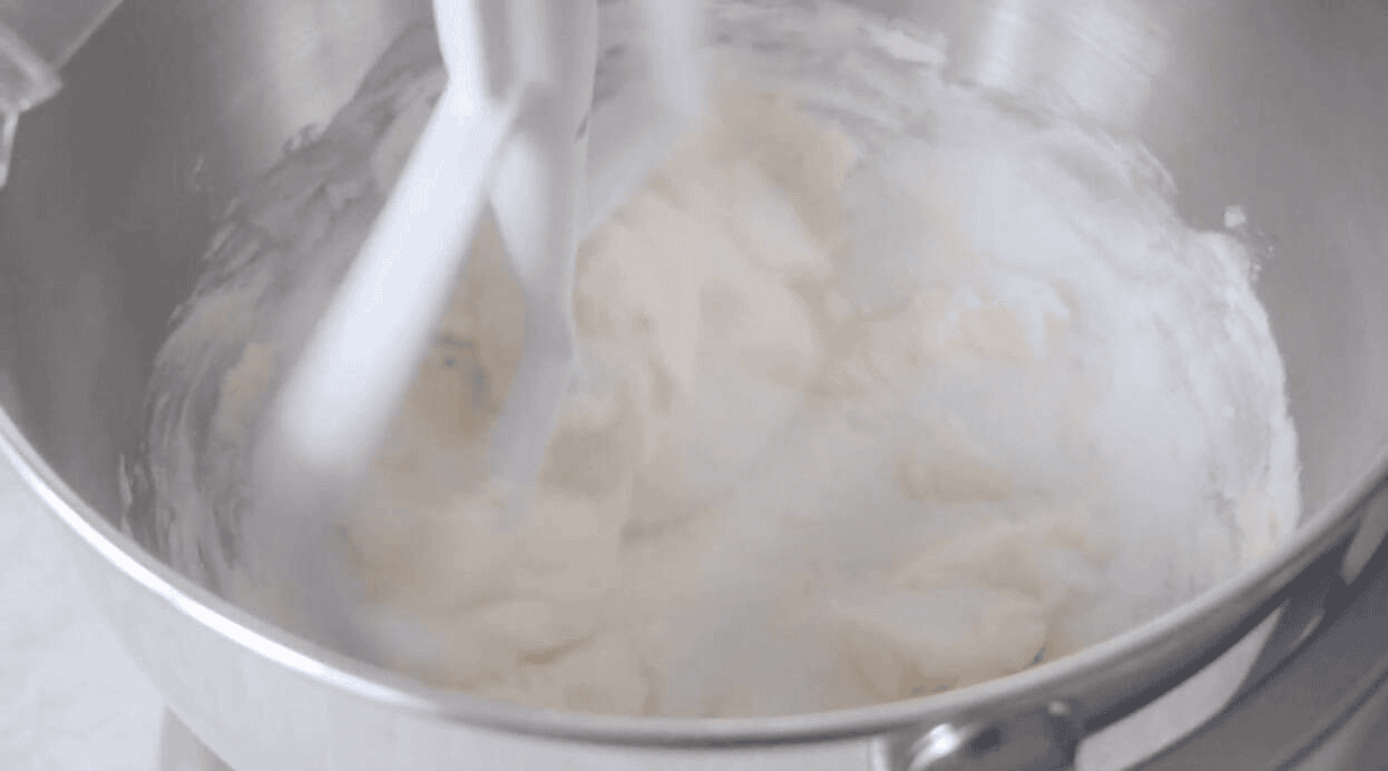 Bowl of sugar and butter creamed in stand mixer.