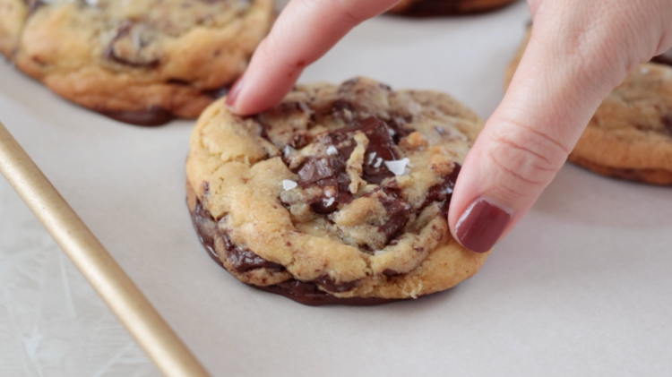 hand pressing a dipped cookie onto a baking sheet