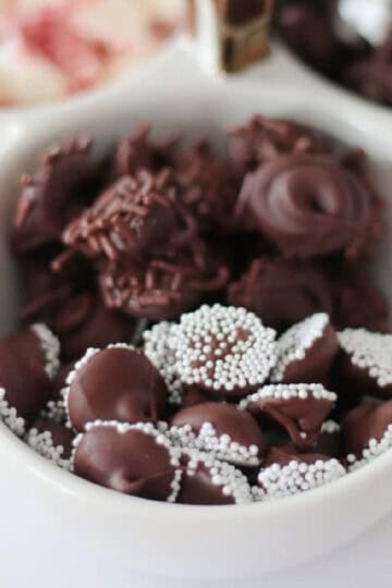 White bowl of chocolate nonpareils candy.