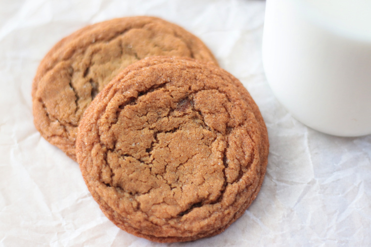 two molasses cookies with glass of milk