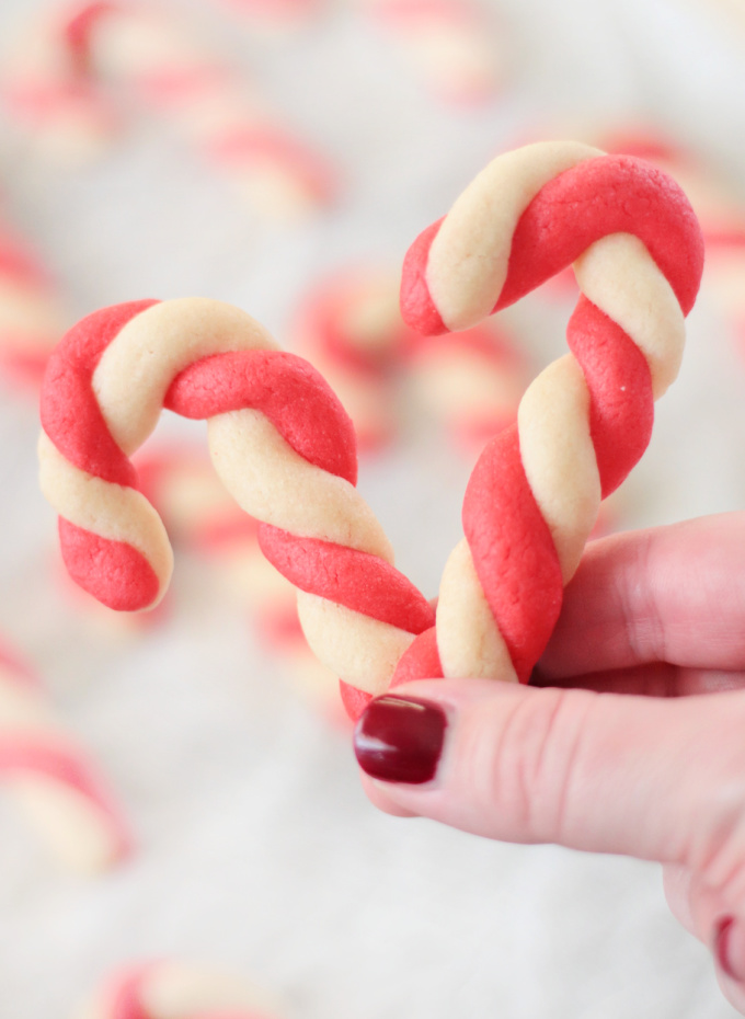 hand holding two candy cane sugar cookies
