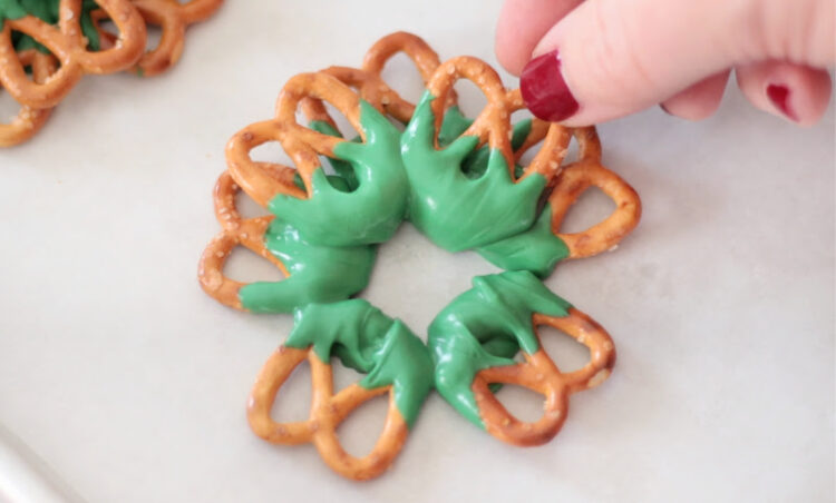 hand placing row of pretzels on top of pretzel wreaths