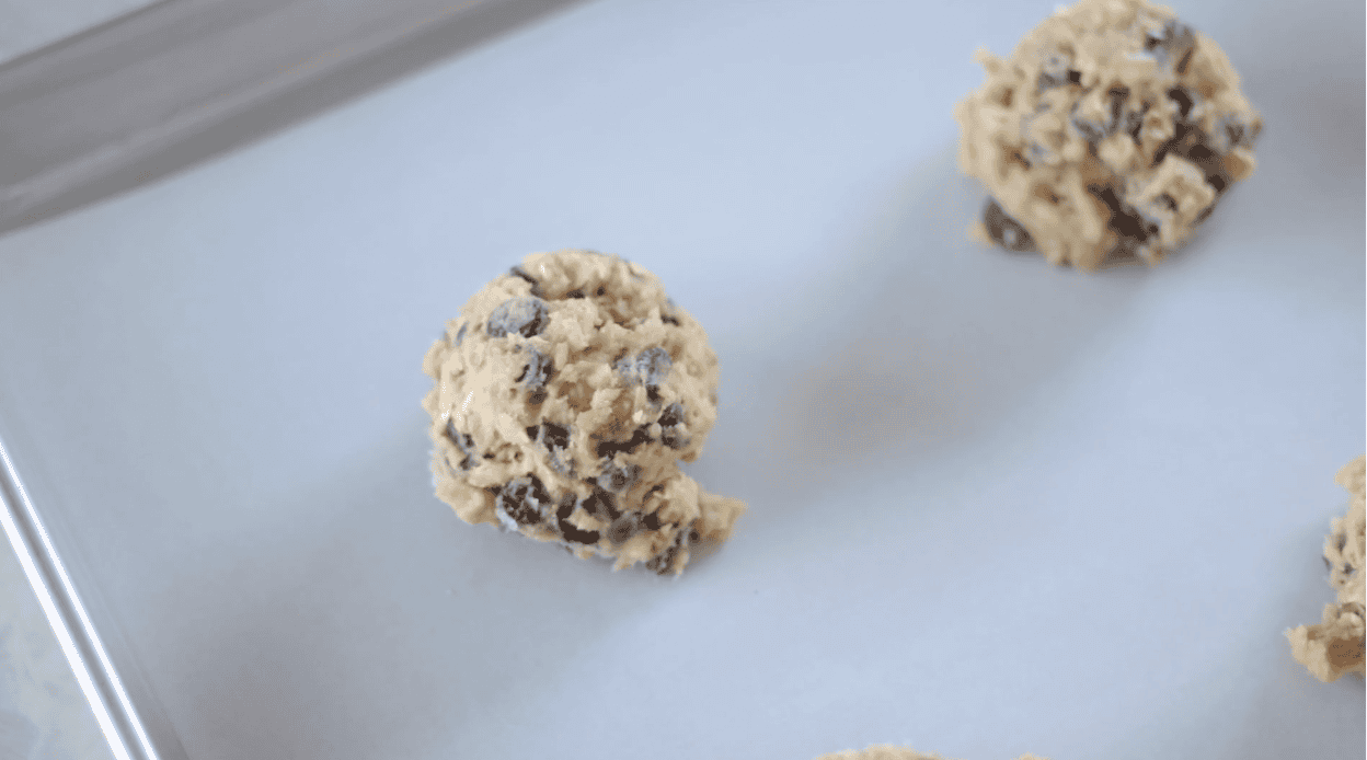 Cookie dough on parchment lined baking sheets.