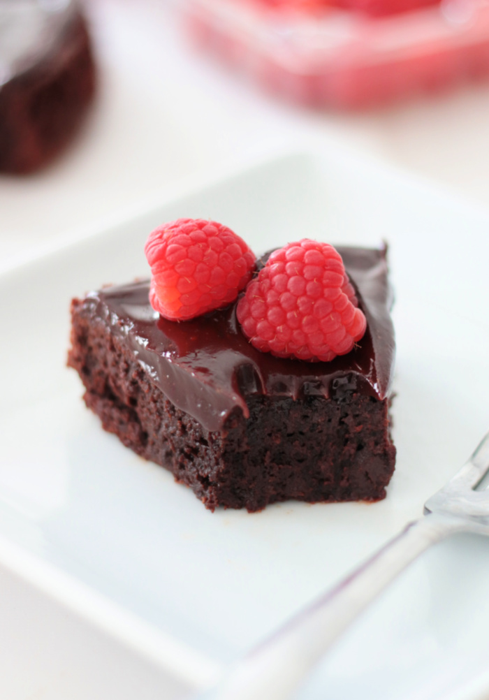 chocolate cake on plate with fresh raspberries