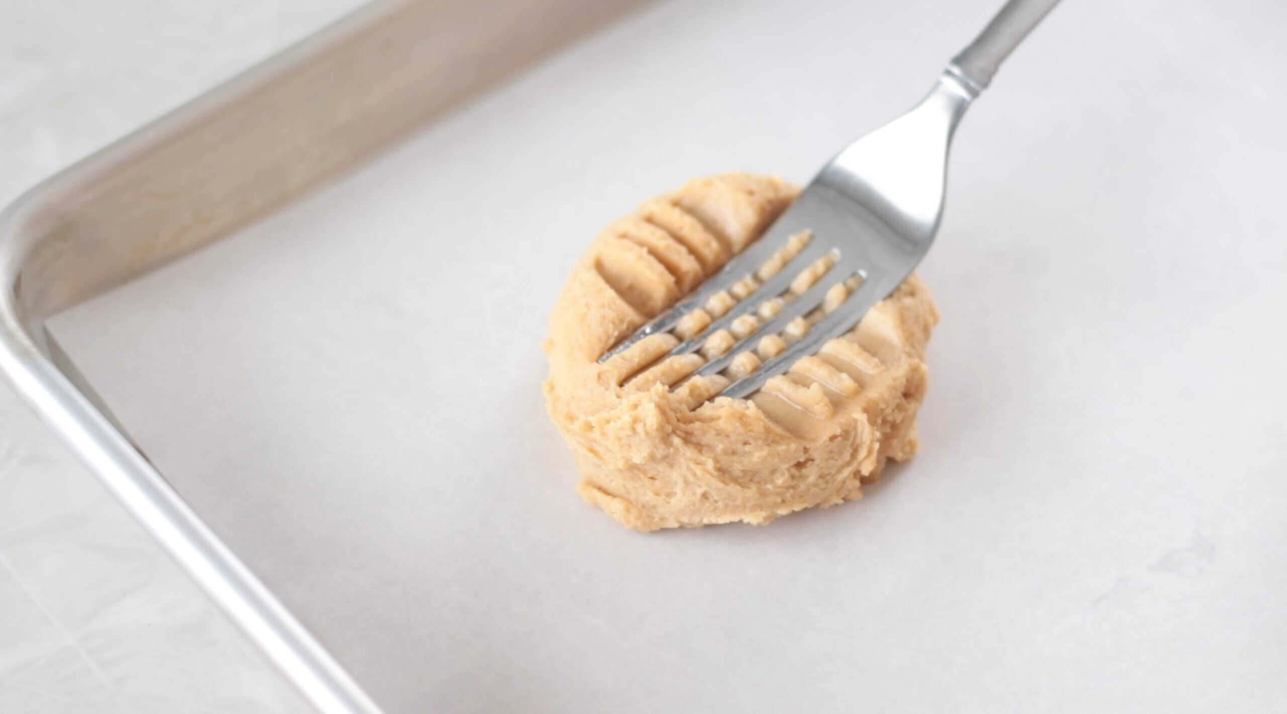 Fork pressed onto cookie dough ball.
