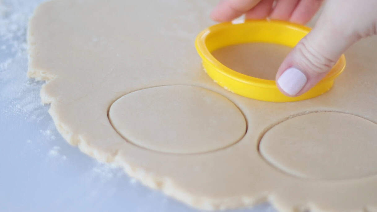 Oval sugar cookies cut out with cookie cutter.