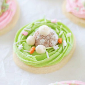 Oval bunny butt sugar cookie with green frosting and donut hole on top.