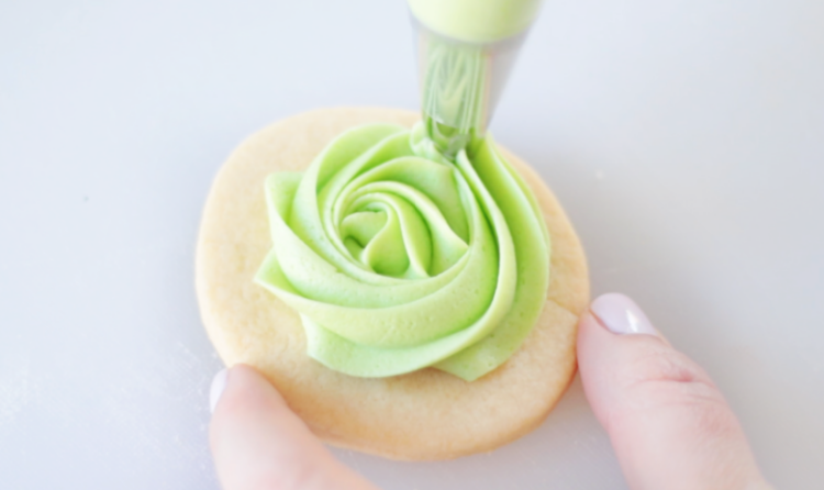 green frosting piped onto sugar cookie